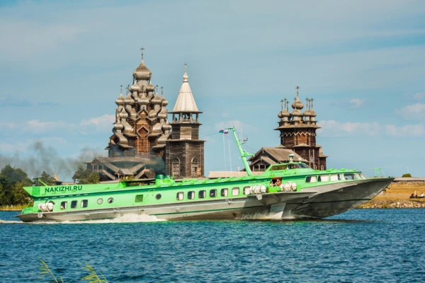 Судно на подводных крыльях движется на фоне острова Кижи. Летний солнечный день
