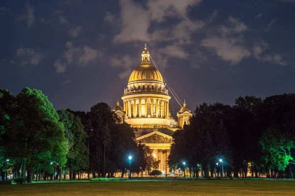 Gorgeous Saint Isaac's Cathedral in night illumination between trees of Alexander Garden in Saint Petersburg, Russia. Neoclassical church, one of the main travel destinations in Saint-Petersburg.